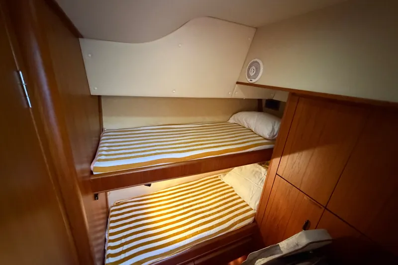 Slide: The Image of Bunk beds in 2000 Tiara Yachts 4300 Convertible cabin with striped bedding. - 32
