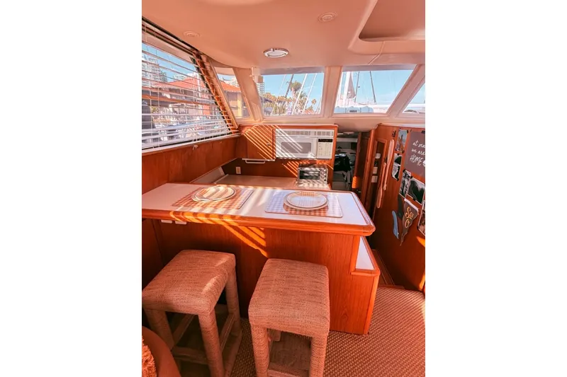 Slide: The Image of Interior of 2000 Tiara Yachts 4300 Convertible with cozy dining area and natural light. - 18