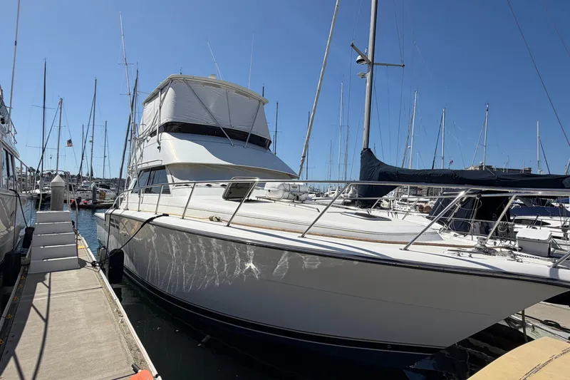 Slide: The Image of 2000 Tiara Yachts 4300 Convertible docked at marina under clear blue sky. - 1