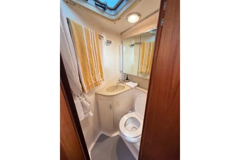 Slide: The Image of Bathroom interior of 2000 Tiara Yachts 4300 Convertible with sink, toilet, and towels. - 16