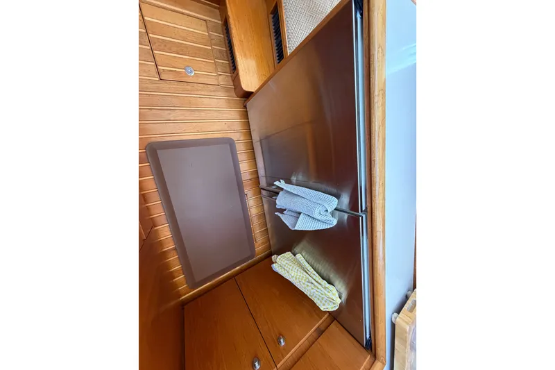 Slide: The Image of Interior of 2000 Tiara Yachts 4300 Convertible, featuring wooden cabinetry and stainless steel appliances. - 33