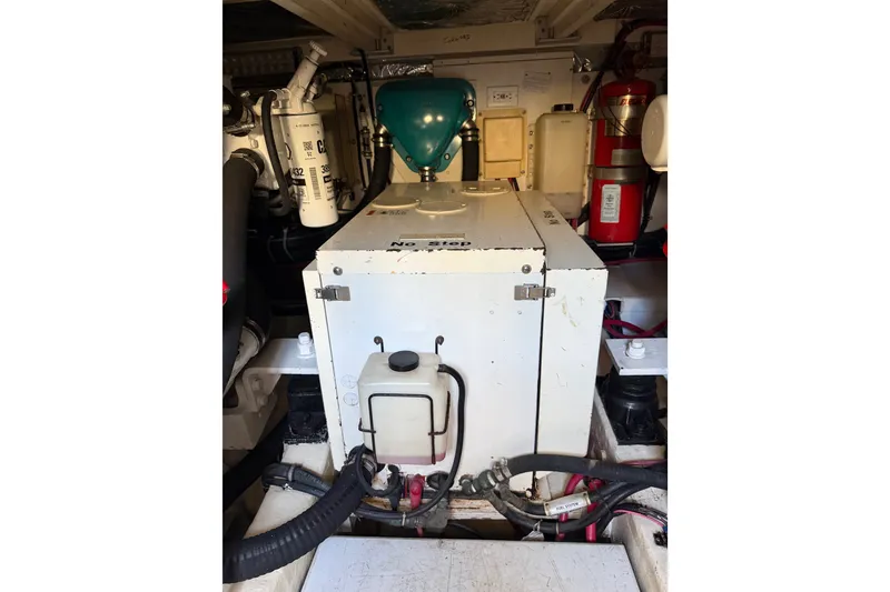 Slide: The Image of Engine room of 2000 Tiara Yachts 4300 Convertible, featuring mechanical components and fire extinguisher. - 43