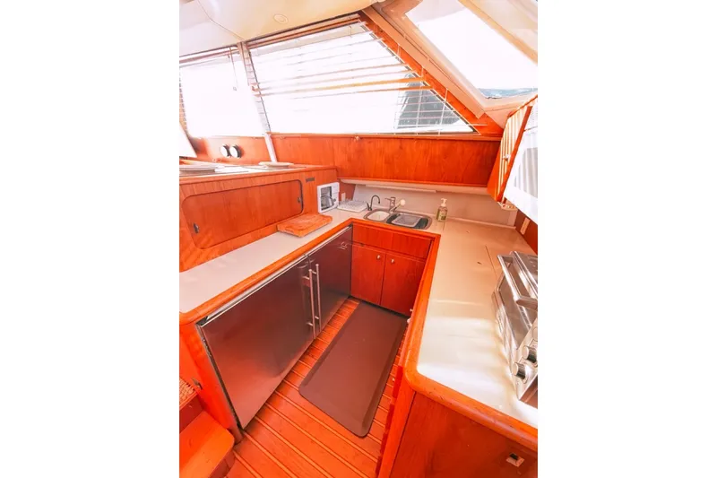Slide: The Image of Interior of 2000 Tiara Yachts 4300 Convertible, featuring a compact, well-equipped kitchen area. - 24