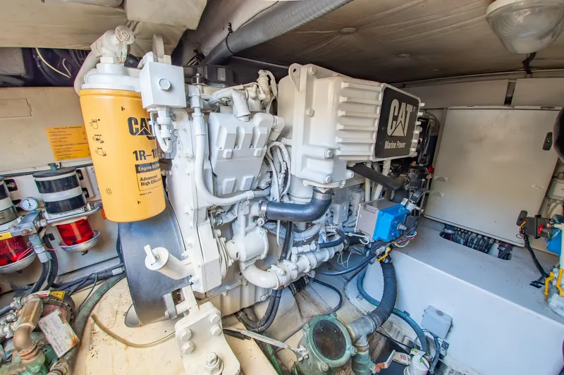Slide: The Image of The engine room of a 2008 Azimut 47 features a CAT engine with various components and hoses. - 38