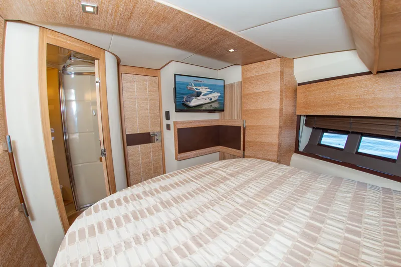 Slide: The Image of The cabin of a 2008 Azimut 47 with a double bed and a flat-screen TV. - 27