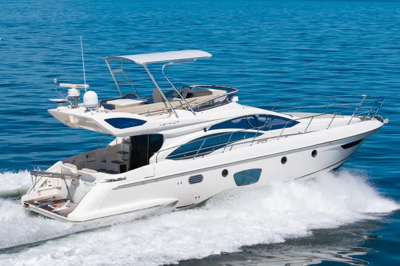 Slide: The Image of A luxurious 2008 Azimut 47 yacht cruising swiftly over blue waters. - 1