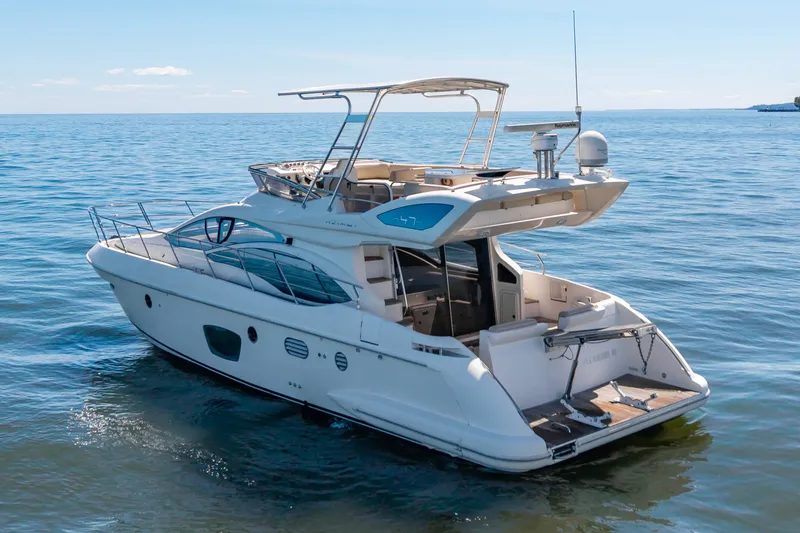 Slide: The Image of A 2008 Azimut 47 yacht on calm water. It features sleek design and an open deck. - 40