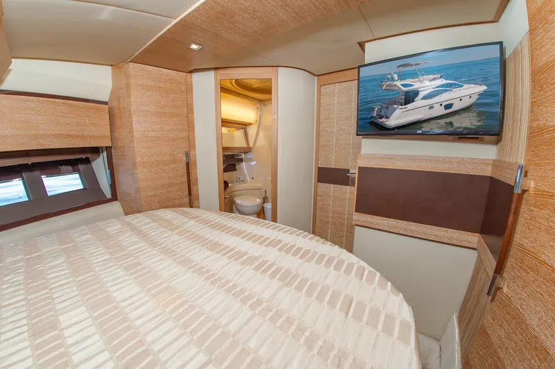 Slide: The Image of The cabin of a 2008 Azimut 47 with a large bed and a television. - 28