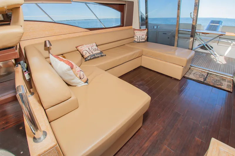 Slide: The Image of Luxurious salon with beige leather sofas and decorative pillows, offering a view of the sea through large windows. - 20