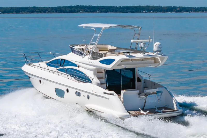Slide: The Image of A 2008 Azimut 47 yacht speeds across the water, showcasing a clear view of the deck. - 3