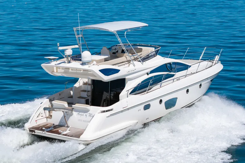 Slide: The Image of A 2008 Azimut 47 yacht cruising on calm water with a clear blue sky. - 2