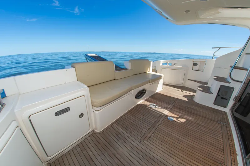 Slide: The Image of The 2008 Azimut 47 features a spacious deck with beige seating and wooden flooring. - 10