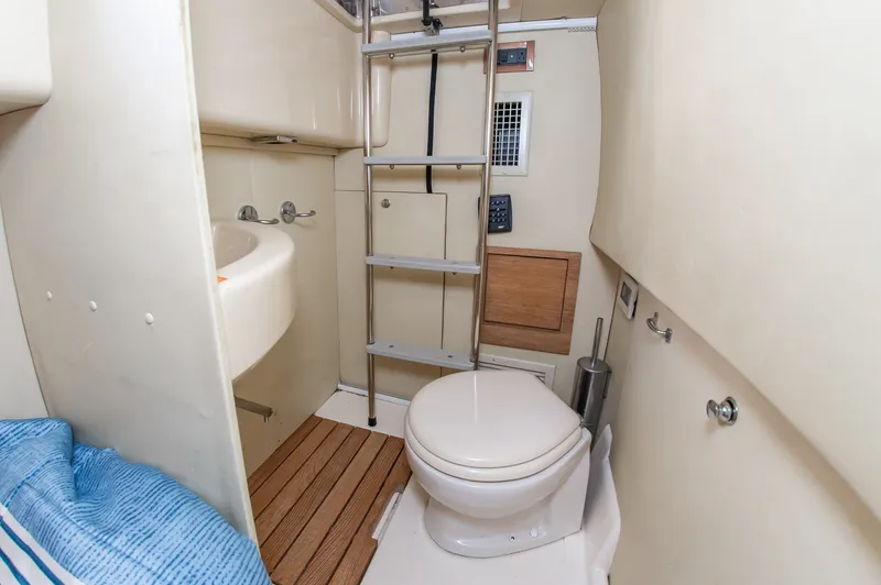 Slide: The Image of The image shows a bathroom on a 2008 Azimut 47 yacht. It features a toilet, sink, and ladder. - 36