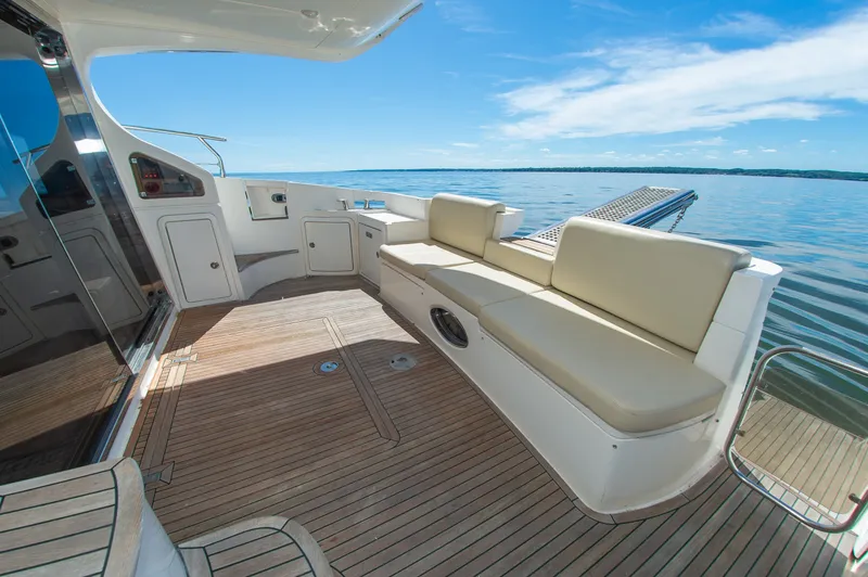 Slide: The Image of The 2008 Azimut 47 features a sleek deck with beige seating and a clear view of the water. - 11