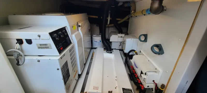 Slide: The Image of The engine room of a 2006 Viking Princess 61 Flybridge shows technical equipment and wiring. - 27