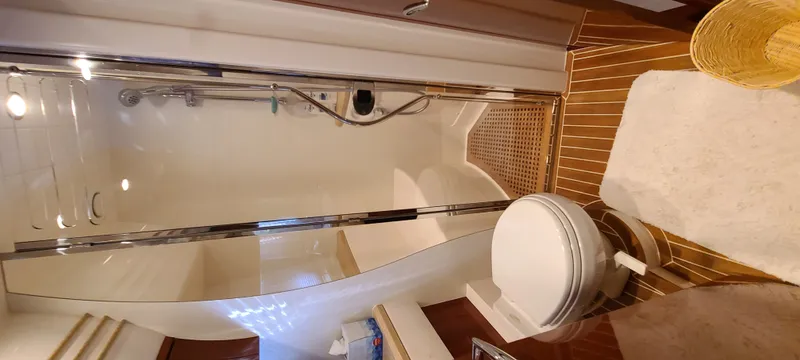 Slide: The Image of The image shows a yacht bathroom with a shower and toilet. - 23