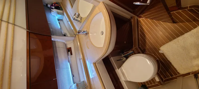 Slide: The Image of The image shows an elegant yacht bathroom with dual sinks and a toilet. - 21