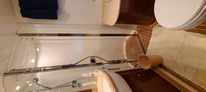 Slide: The Image of The image shows an elegant yacht bathroom with a shower, sink, and toilet. - 25