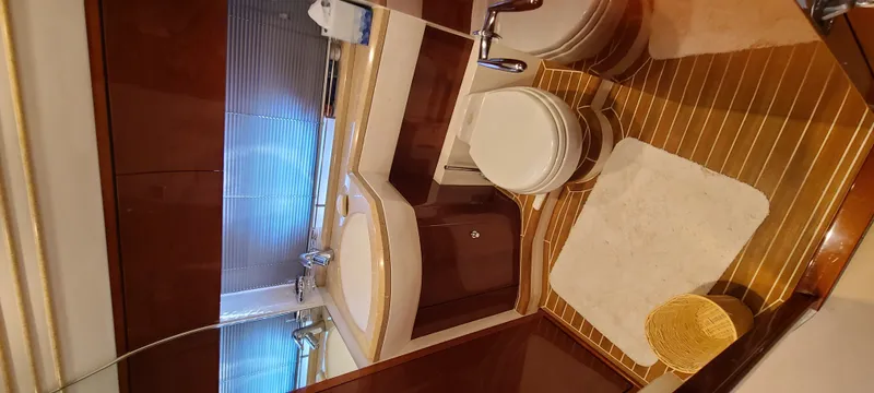 Slide: The Image of The image shows a luxurious yacht bathroom with wooden flooring, toilet, and sink. - 22