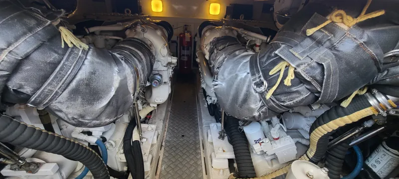Slide: The Image of The engine room of a 2006 Viking Princess 61 Flybridge showing two large engines. - 26