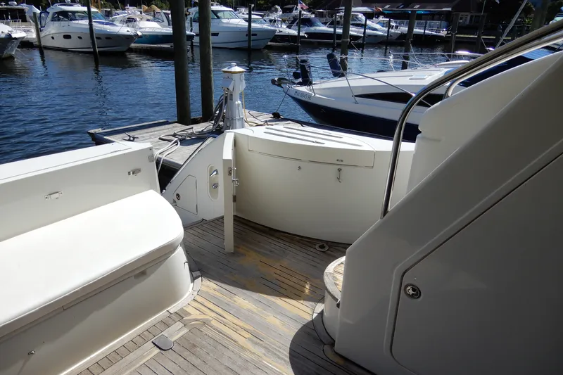 Slide: The Image of 2008 Viking Sport Cruisers 61 Motor Yacht docked, showcasing elegant deck and seating area. - 12