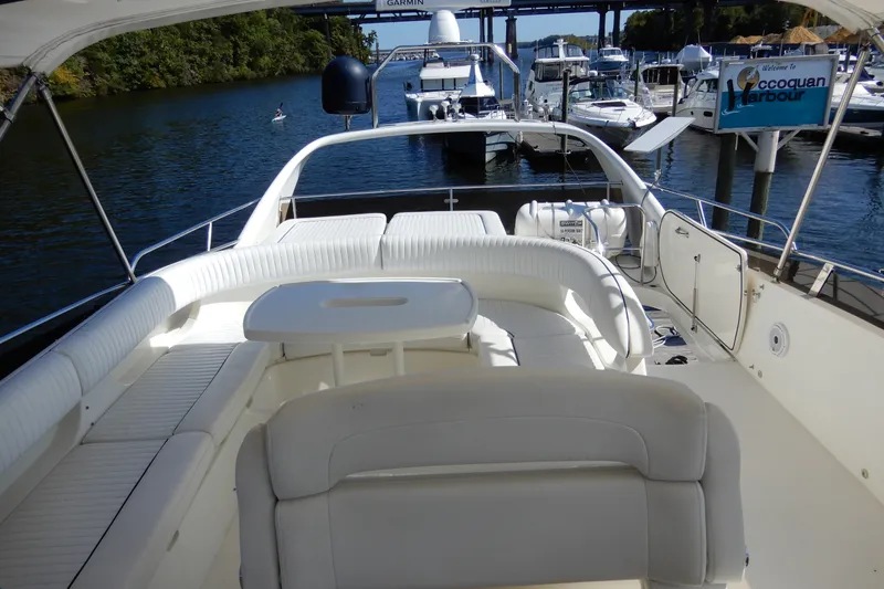 Slide: The Image of 2008 Viking Sport Cruisers 61 Motor Yacht at dock, featuring spacious seating and scenic harbor view. - 29