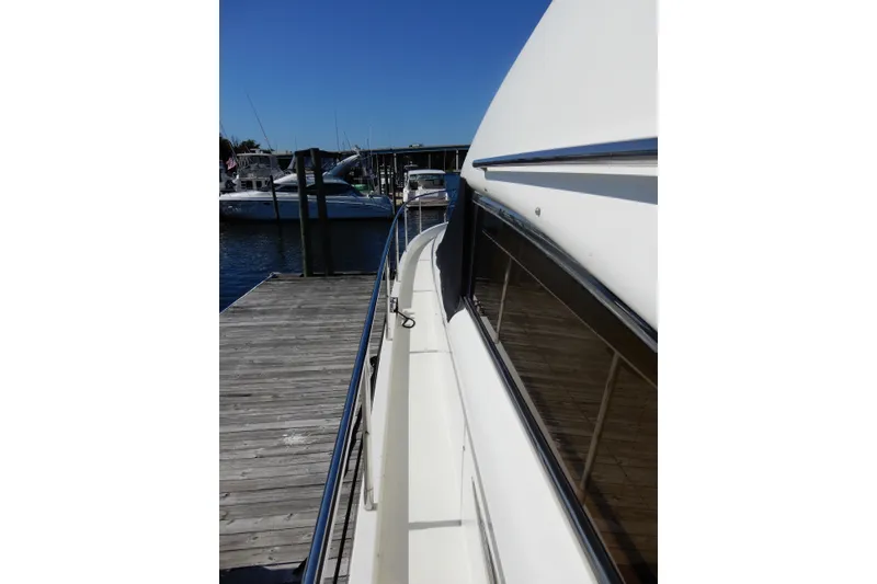 Slide: The Image of 2008 Viking Sport Cruisers 61 Motor Yacht docked at marina under clear blue sky. - 23