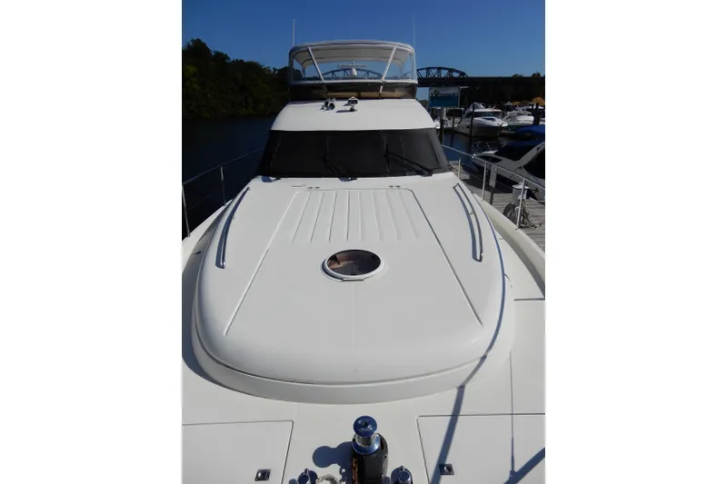 Slide: The Image of 2008 Viking Sport Cruisers 61 Motor Yacht docked, showcasing sleek design and spacious deck. - 20