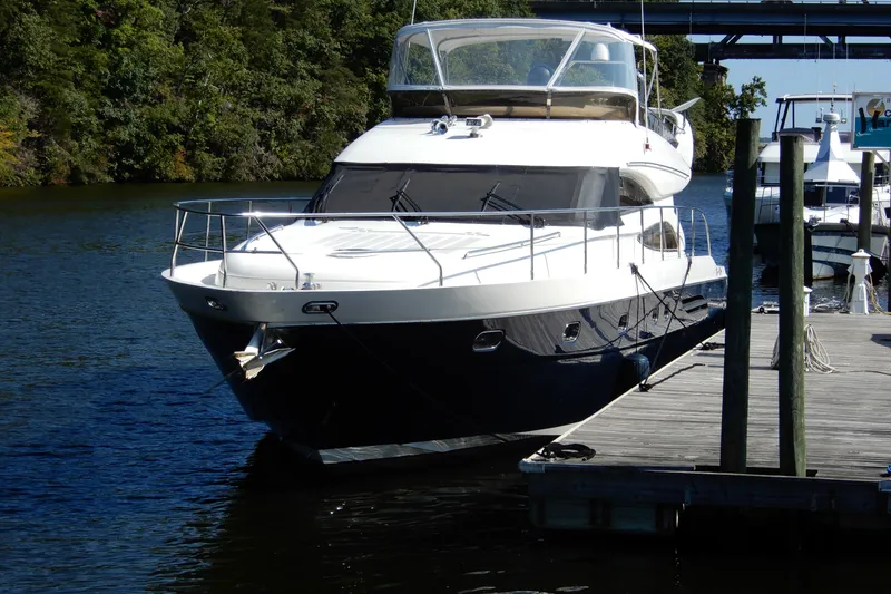Slide: The Image of 2008 Viking Sport Cruisers 61 Motor Yacht docked on a serene river. - 2
