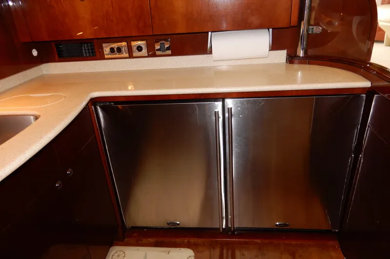 Slide: The Image of 2008 Viking Sport Cruisers 61 Motor Yacht kitchen with stainless steel fridge and wooden cabinetry. - 72