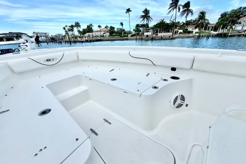 Slide: The Image of 2017 Sea Hunt Gamefish 27 boat interior with white seating and storage, dockside view. - 23