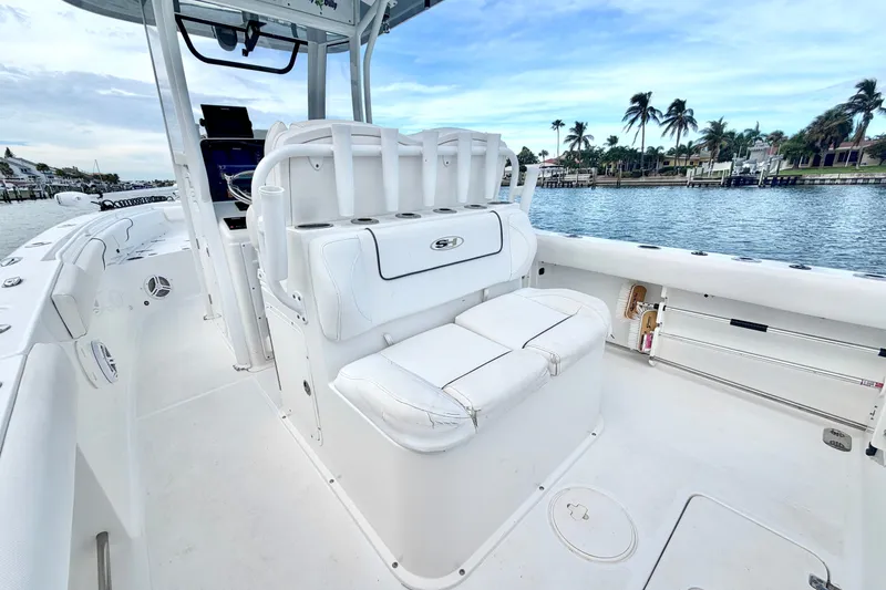 Slide: The Image of 2017 Sea Hunt Gamefish 27 boat interior with white seating, ocean view, and palm trees. - 14