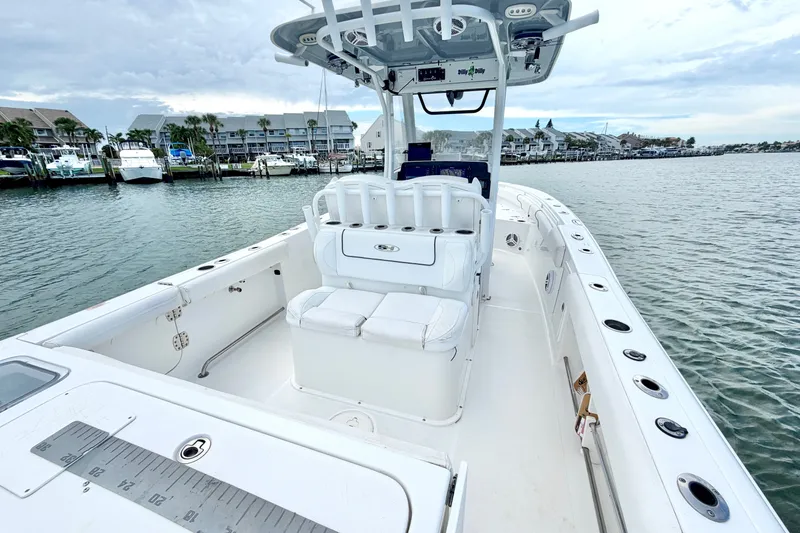 Slide: The Image of 2017 Sea Hunt Gamefish 27 boat on calm water, featuring spacious deck and seating. - 10