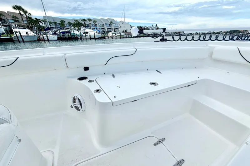 Slide: The Image of 2017 Sea Hunt Gamefish 27 boat interior with seating and storage, docked at marina. - 21