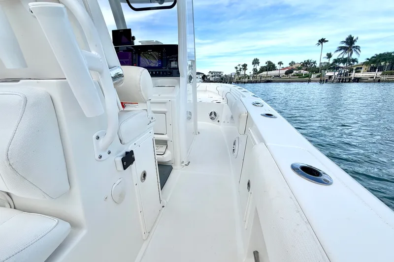 Slide: The Image of 2017 Sea Hunt Gamefish 27 boat interior with white seating, on calm water. - 19