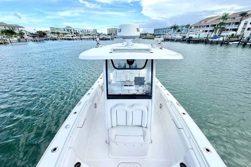 Slide: The Image of 2017 Sea Hunt Gamefish 27 boat docked in a marina with waterfront buildings. - 26