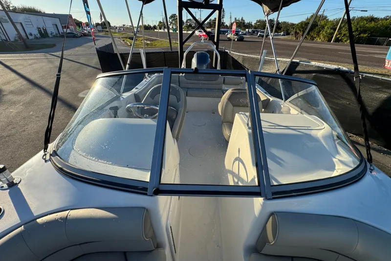 Slide: The Image of 2021 Key West 203 DFS boat interior with seating and steering wheel, parked outdoors. - 43