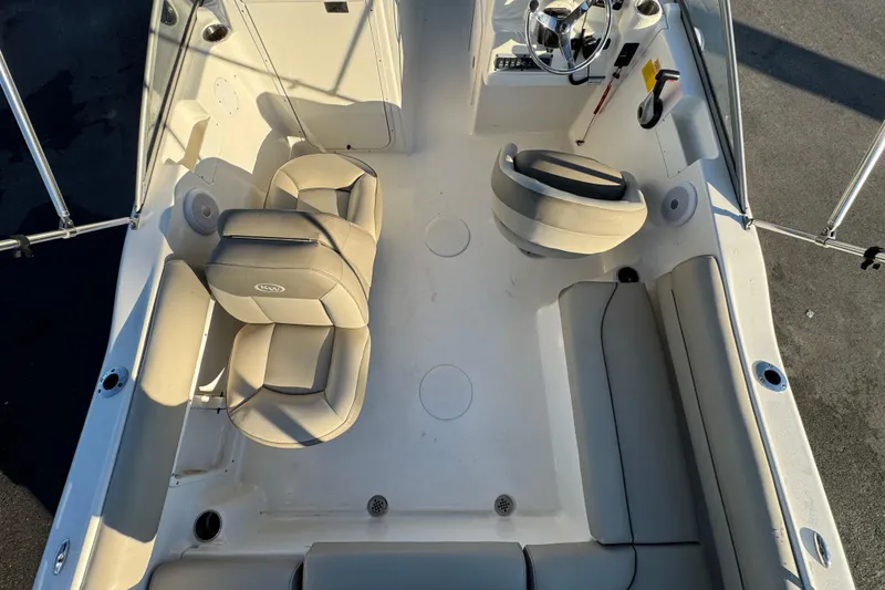 Slide: The Image of 2021 Key West 203 DFS boat interior with beige seating and steering console. - 16