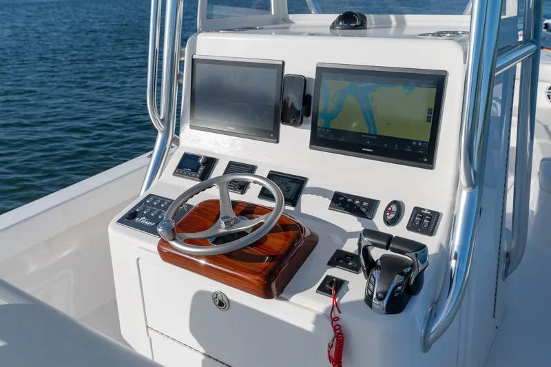 Slide: The Image of 2023 Stuart 27 Center Console boat dashboard with dual screens and steering wheel. - 13