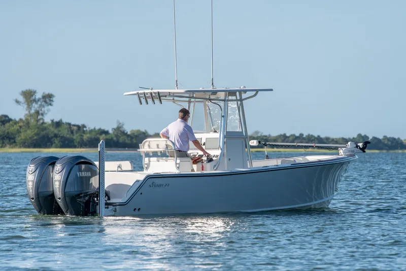 Slide: The Image of 2023 Stuart 27 Center Console boat with dual Yamaha engines on a calm lake. - 7