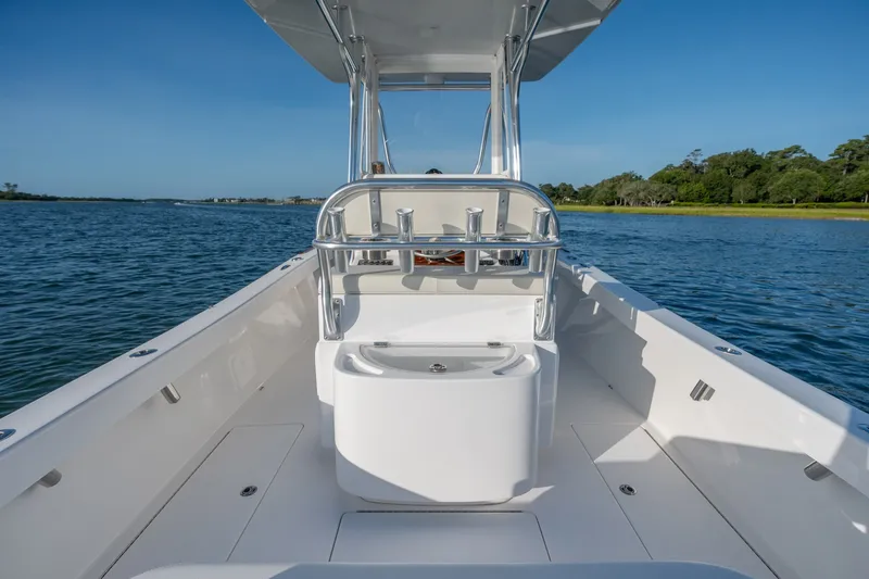 Slide: The Image of 2023 Stuart 27 Center Console boat on calm water, clear sky, and lush shoreline. - 24
