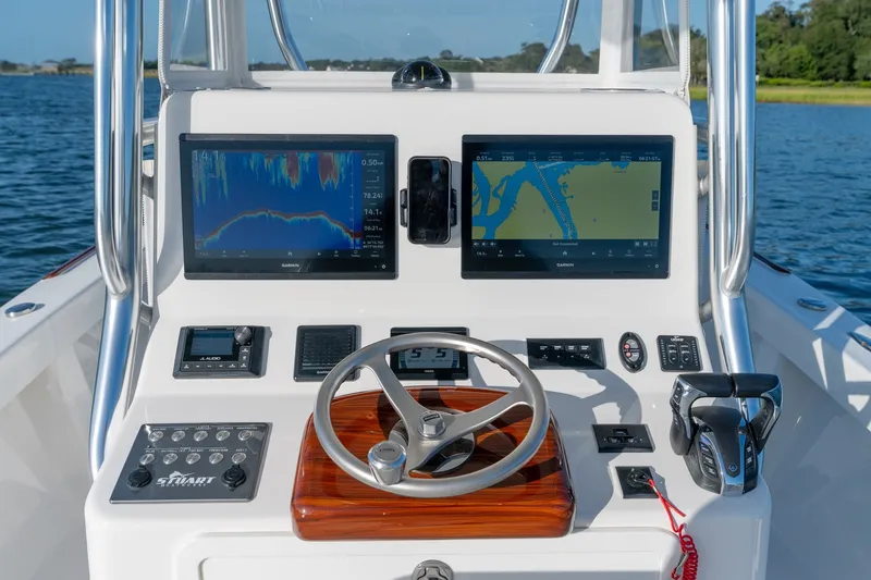 Slide: The Image of 2023 Stuart 27 Center Console boat dashboard with navigation screens and controls. - 12