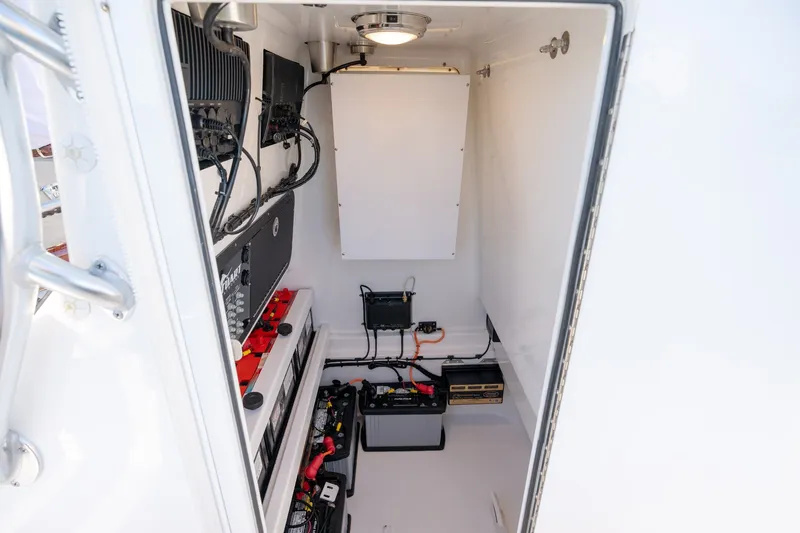 Slide: The Image of Electrical compartment of 2023 Stuart 27 Center Console boat, showcasing wiring and battery setup. - 15