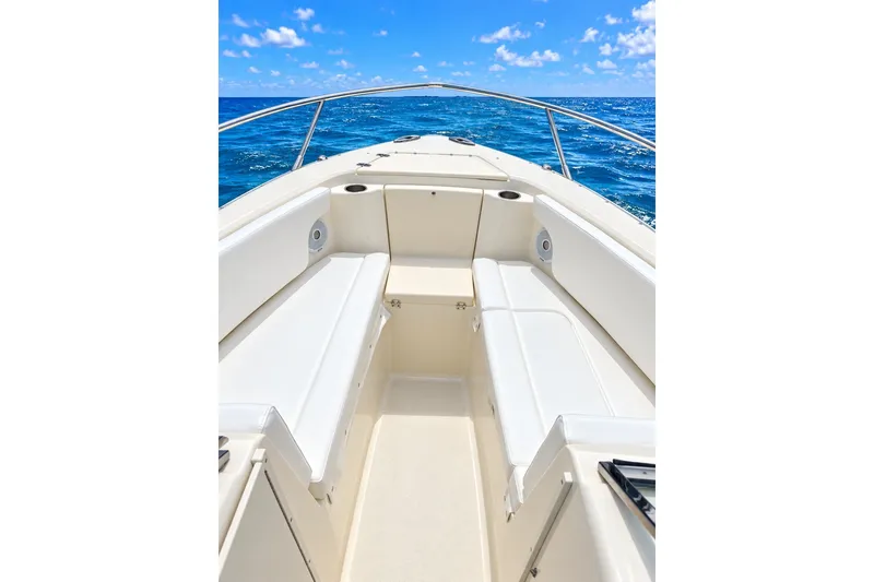 Slide: The Image of 2015 Scout 245 Dorado boat interior with white seating, ocean view, and blue sky. - 4