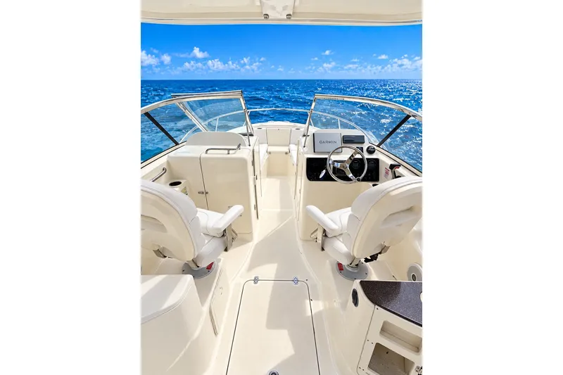 Slide: The Image of 2015 Scout 245 Dorado boat interior with ocean view, featuring dual seats and Garmin navigation. - 9