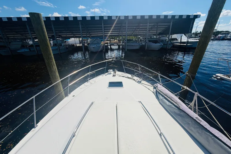 Slide: The Image of Bow view of 2000 Sea Ray 410 Sundancer docked at marina under sunny skies. - 21