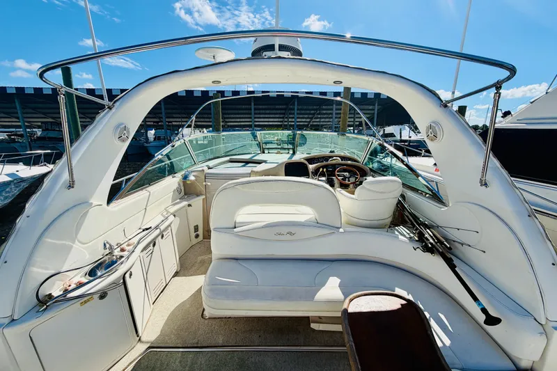 Slide: The Image of 2000 Sea Ray 410 Sundancer yacht interior with helm, seating, and marina backdrop. - 12