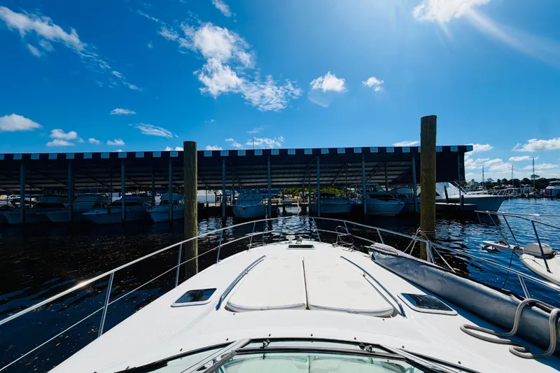 Slide: The Image of Bow view of a 2000 Sea Ray 410 Sundancer docked under a sunny sky. - 18