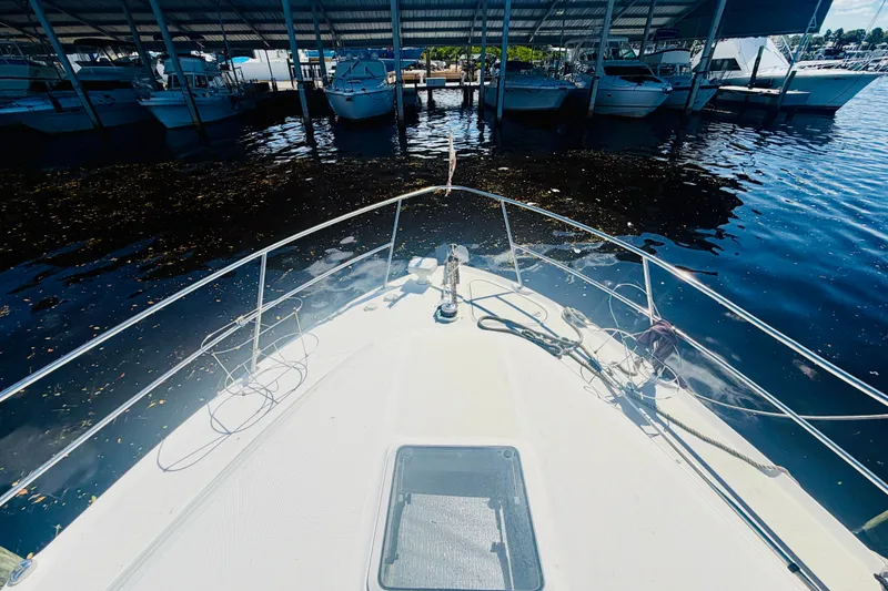 Slide: The Image of Bow view of 2000 Sea Ray 410 Sundancer docked in a marina. - 23