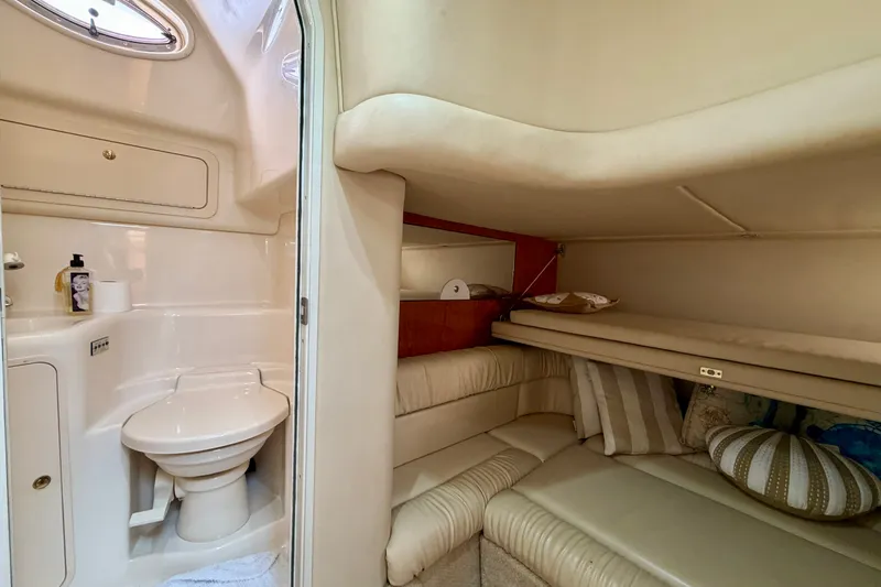 Slide: The Image of Interior of 2000 Sea Ray 410 Sundancer, featuring a compact bathroom and cozy sleeping area. - 67